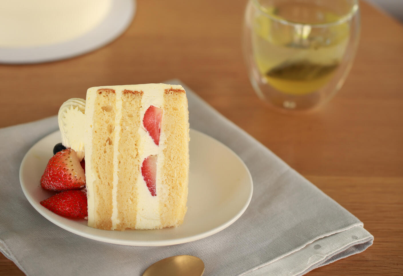 Strawberry sponge cake slice with fresh cream photographed in natural light