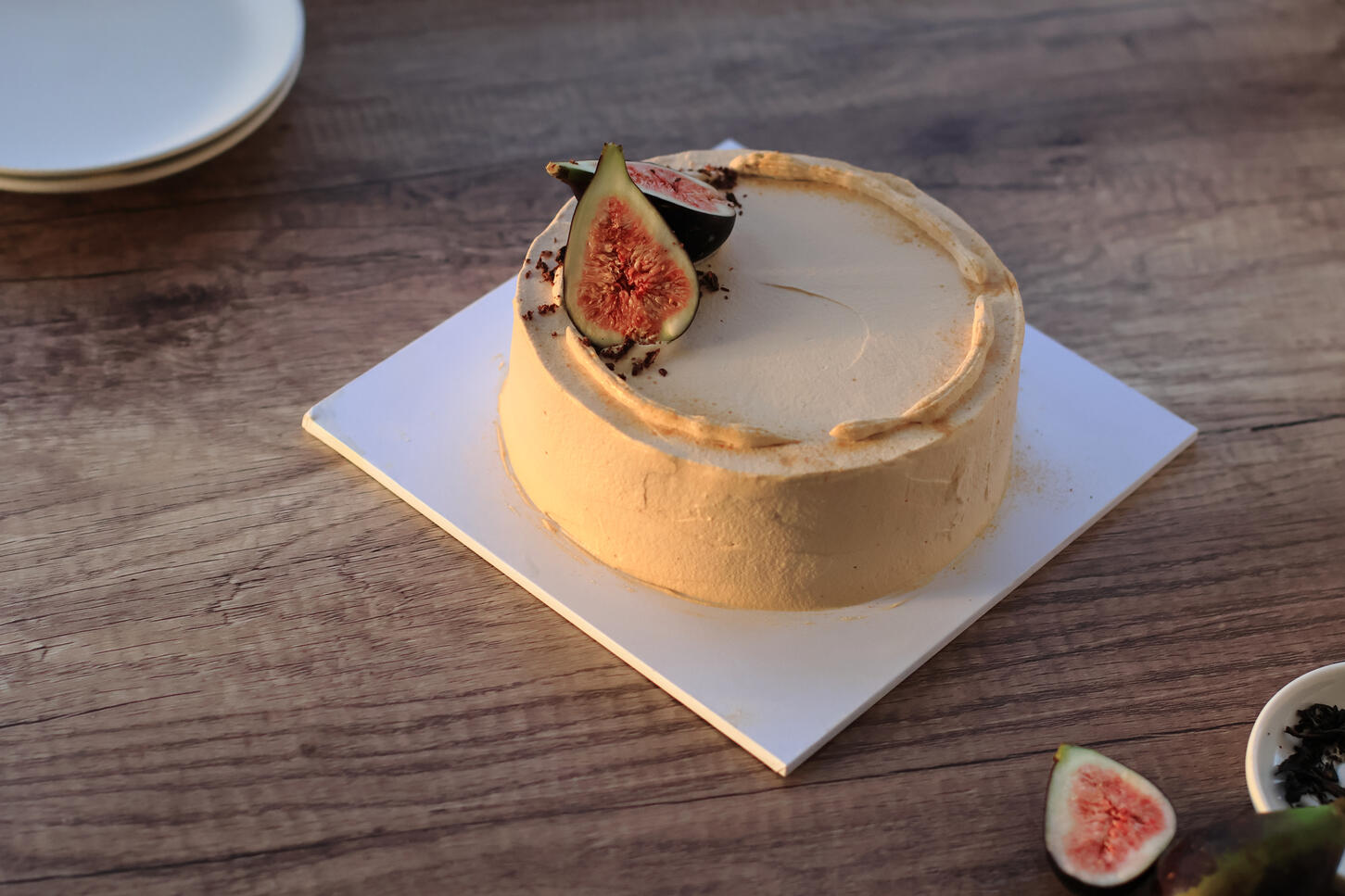 Minimal fig cake photographed in soft side lighting with clean background