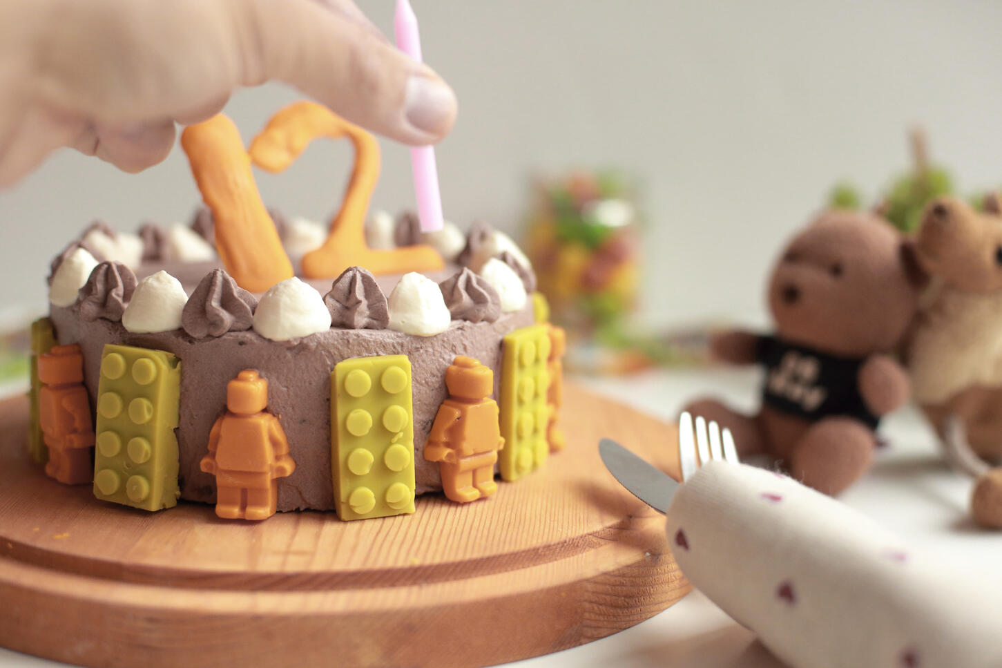 Decorated chocolate celebration cake with colourful toppings in soft focus background