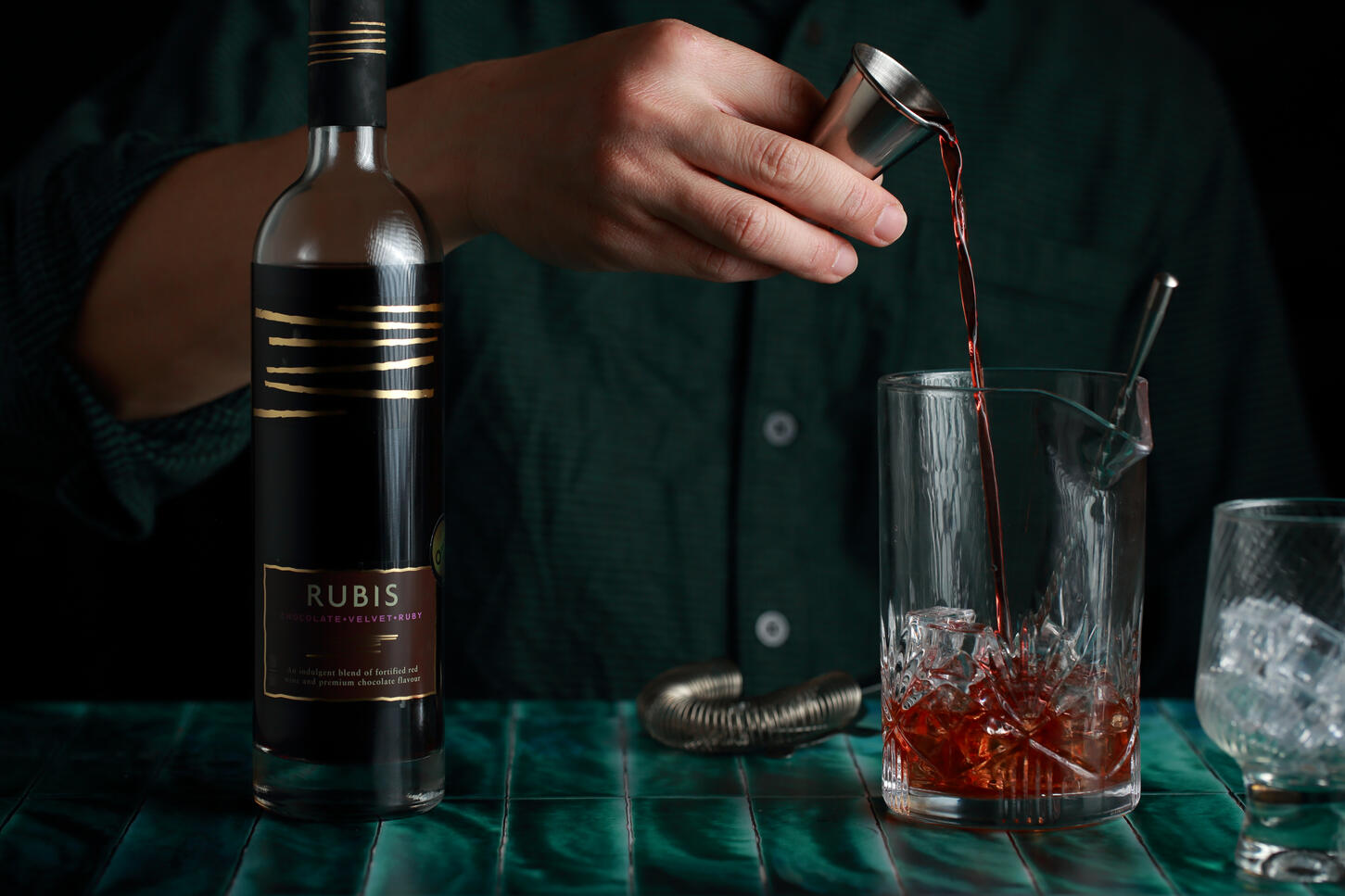 Mixing Rubis wine cocktail in moody bar environment with focused action shot