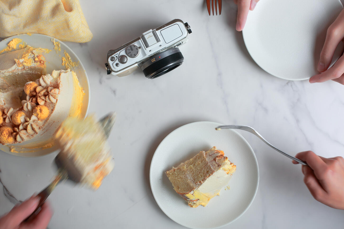 Flat lay of cake being sliced on marble surface in natural light food photography