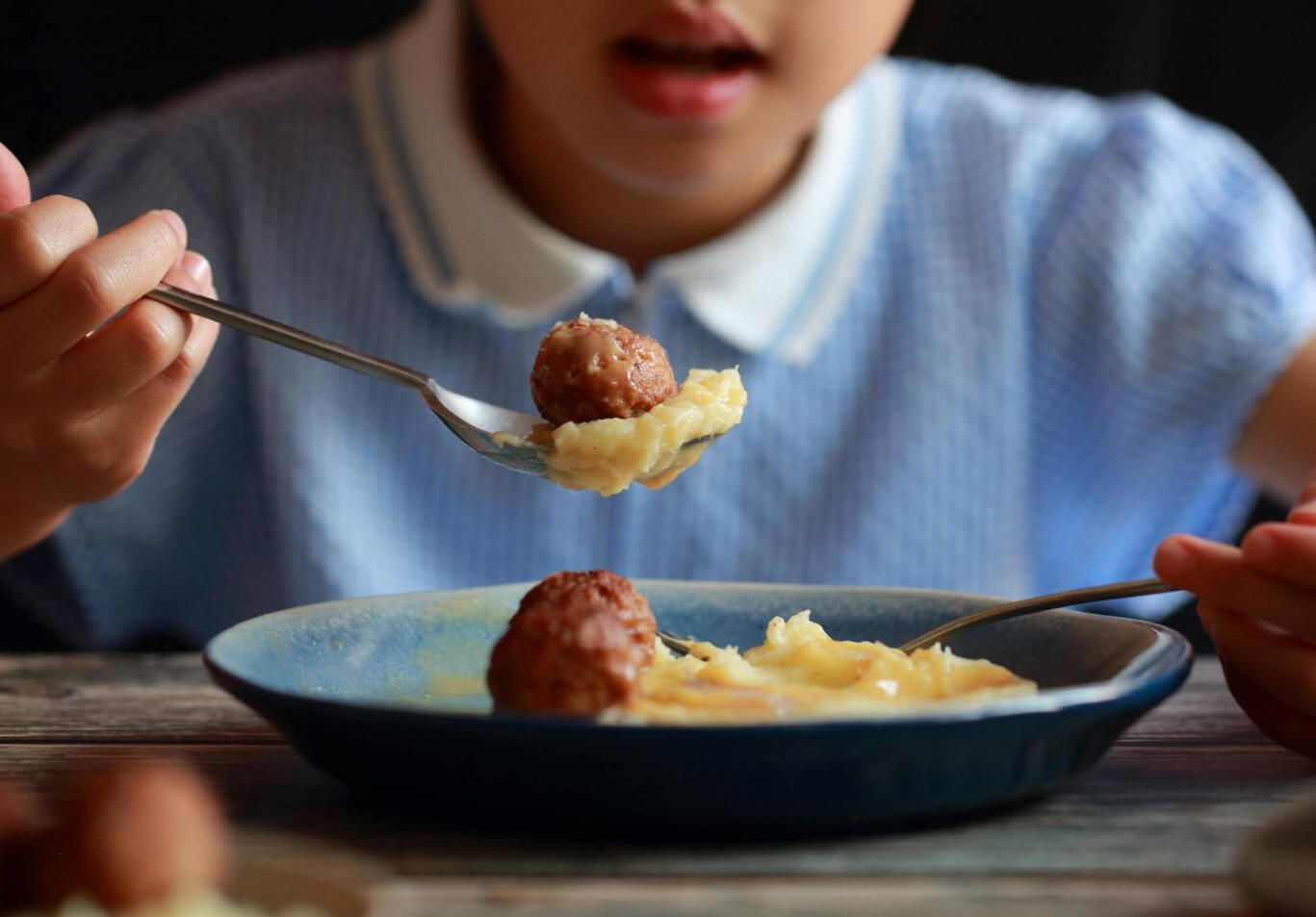 food photography - girl eating meatballs with potato mash food photography - girl eating meatballs with potato mash