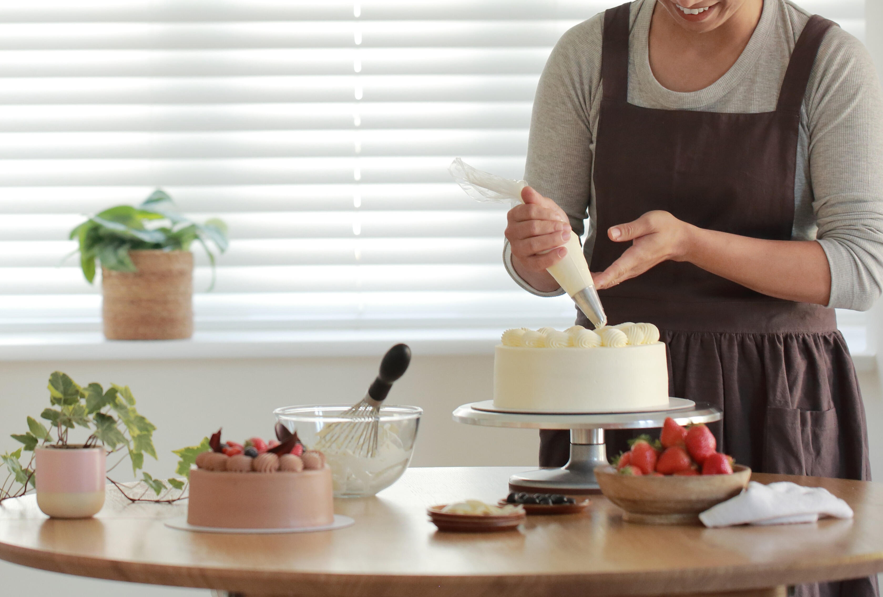Cake making process – behind the scenes Baker decorating strawberry cake in process with fresh ingredients and natural styling for food photography in Horsham serving London and the South East